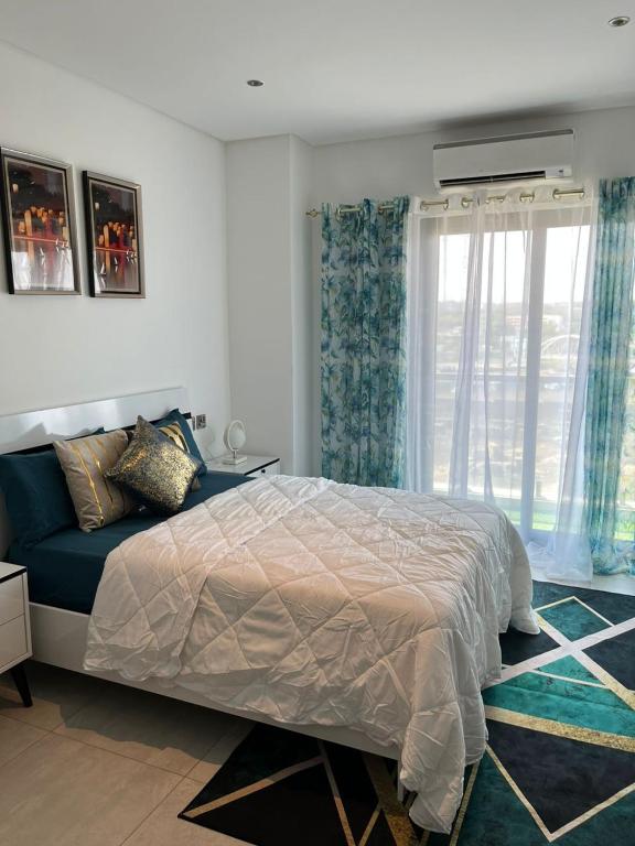 The Lennox by Luxe Properties في آكرا: غرفة نوم بسرير ونافذة
