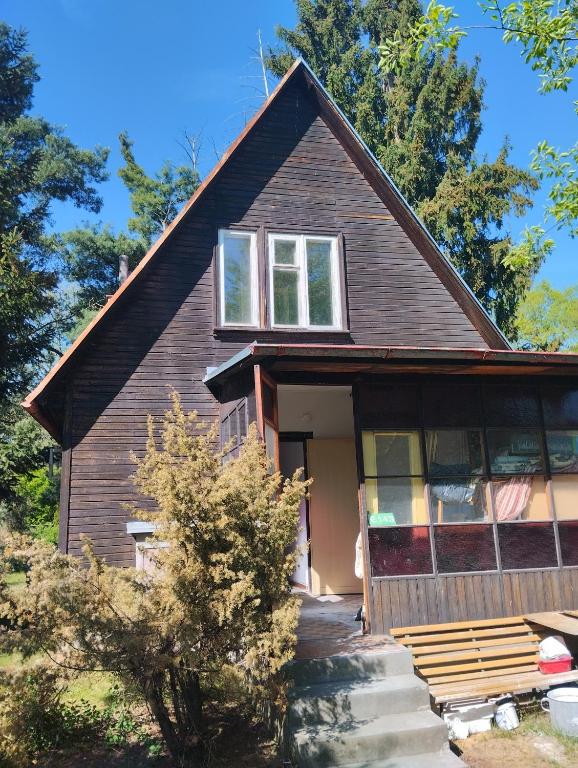 una casa en el bosque con la puerta principal abierta en Chata u řeky Orlice en Hradec Králové