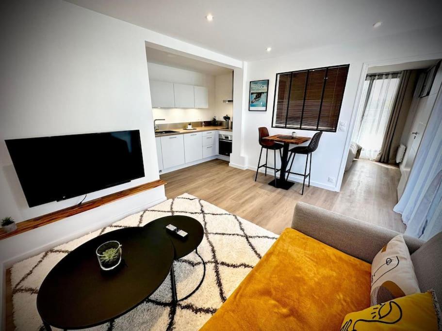 a living room with a couch and a table at Berder - T2 - 10 min gare - terrasse - parking - linge inclus in Vannes