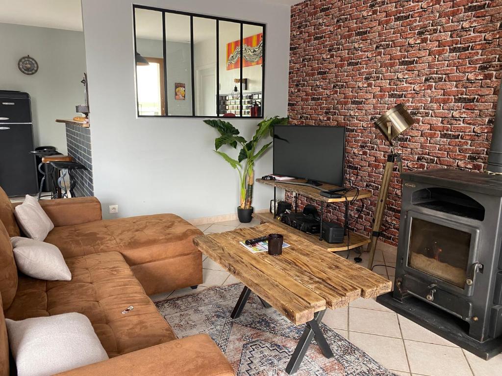 salon z kanapą, stołem i kominkiem w obiekcie Vintage house w mieście Giffaumont