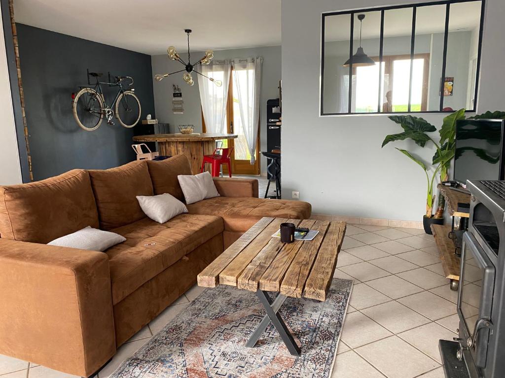 salon z brązową kanapą i stołem w obiekcie Vintage house w mieście Giffaumont