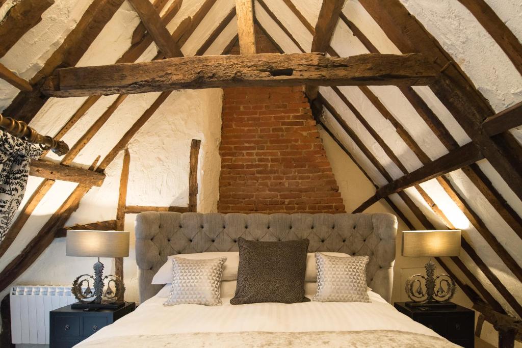 una camera da letto con un letto e due lampade in mansarda di Kings Head Bawburgh a Norwich