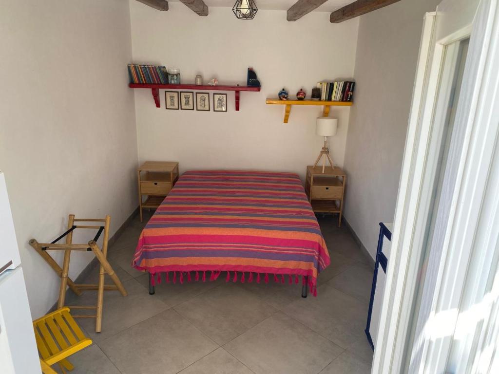 Casa Lilian في سترومبولي: غرفة نوم بسرير وبطانية مخططة