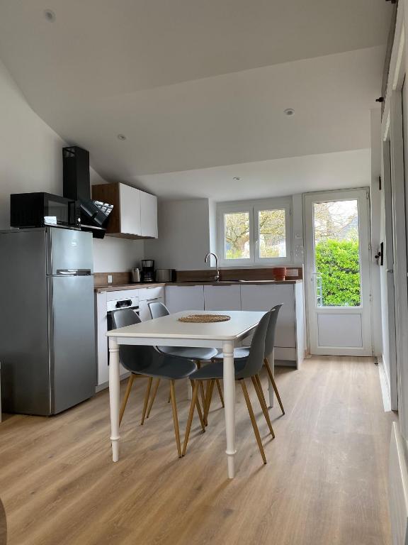 une cuisine avec une table et des chaises dans une pièce dans l'établissement Les Apparts de St Mart, à Bréhal