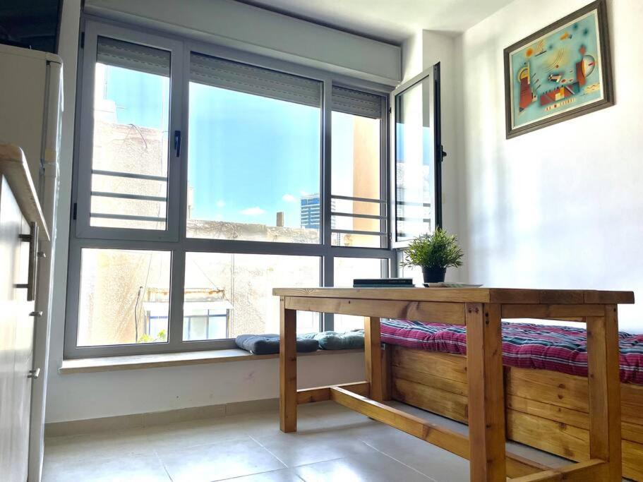 a room with a table and a large window at Two Bedrooms Duplex Apartment l Bugrashov Street l by Bookiz in Tel Aviv