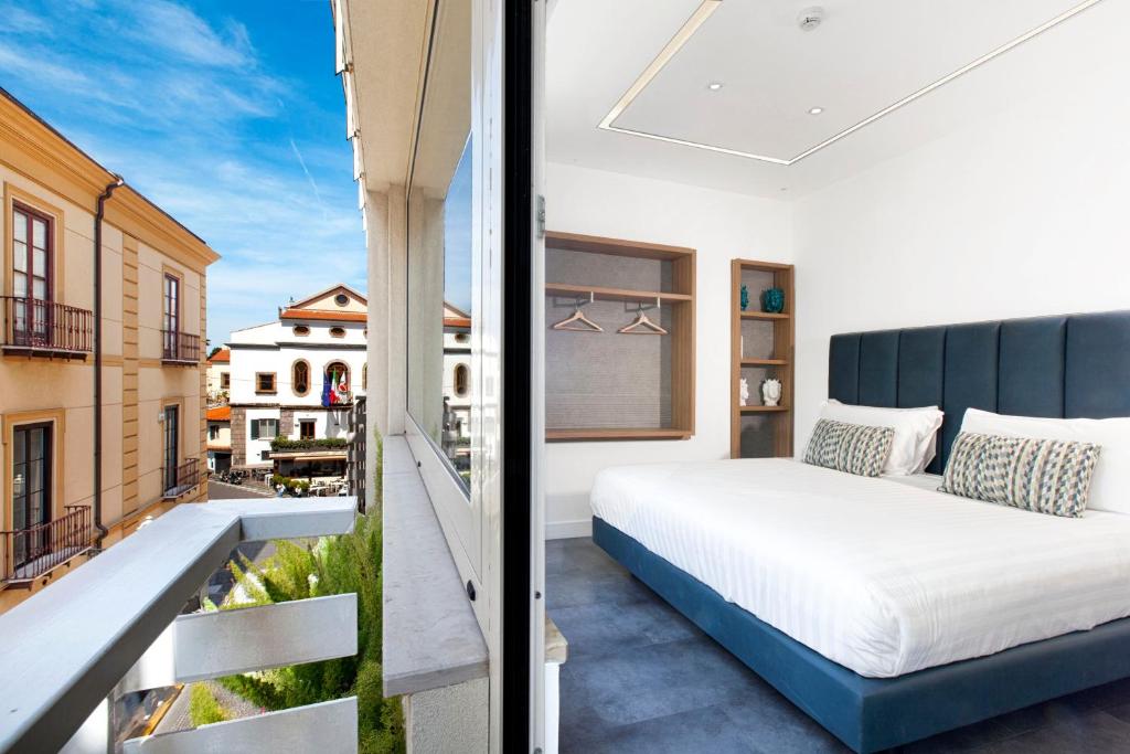 Hotel Tasso Suites & Spa في سورينتو: غرفة نوم مع سرير على شرفة