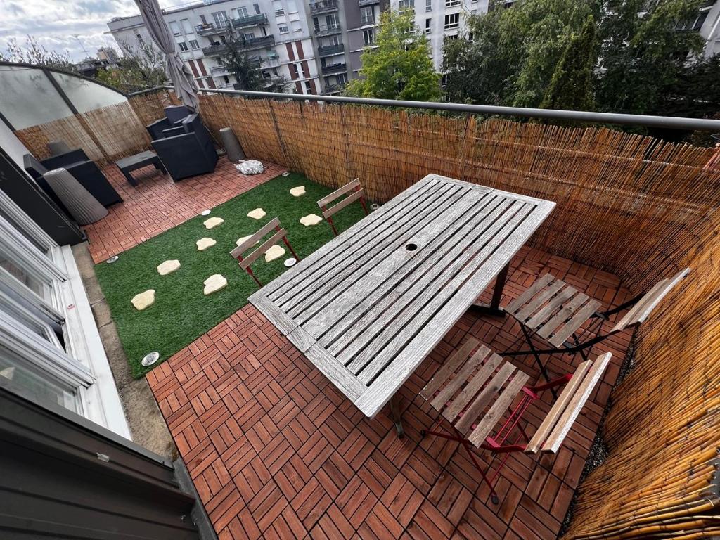 - une table de pique-nique blanche et des chaises sur le balcon dans l'établissement Rooftop Vue sur Paris Tour eiffel Cinq minutes du metro, à Villejuif