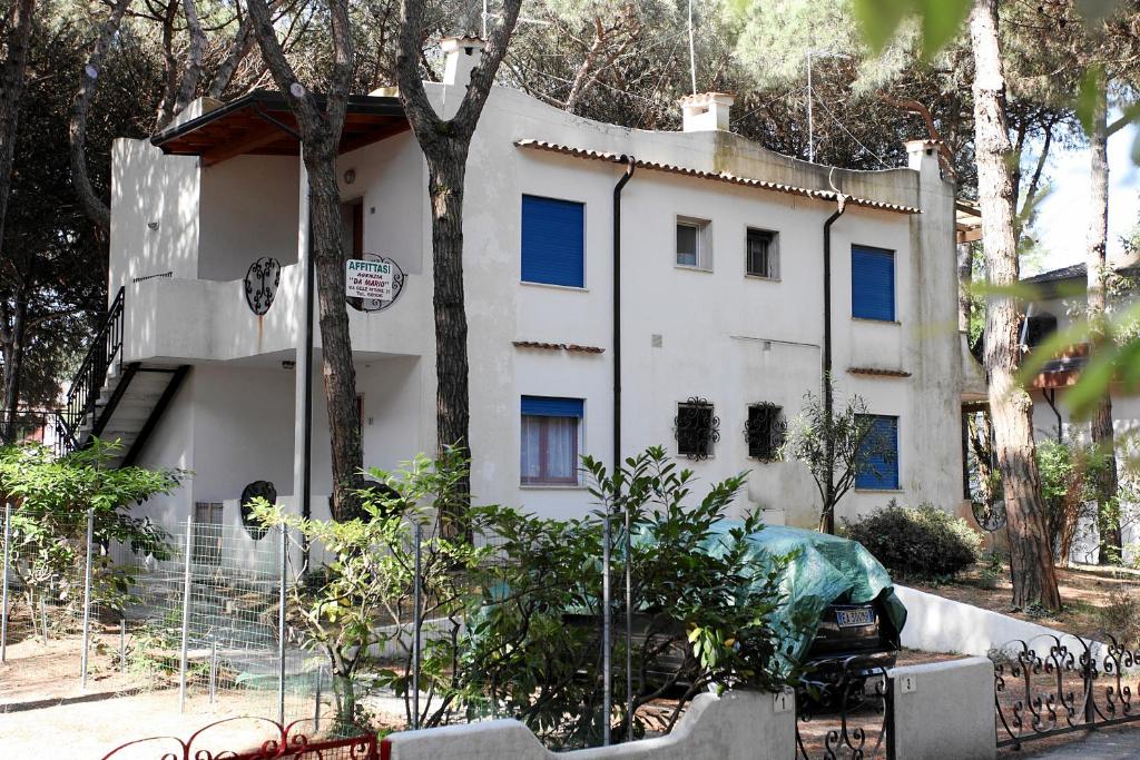 un bâtiment blanc avec des arbres devant lui dans l'établissement Villa Zanella, à Rosolina Mare