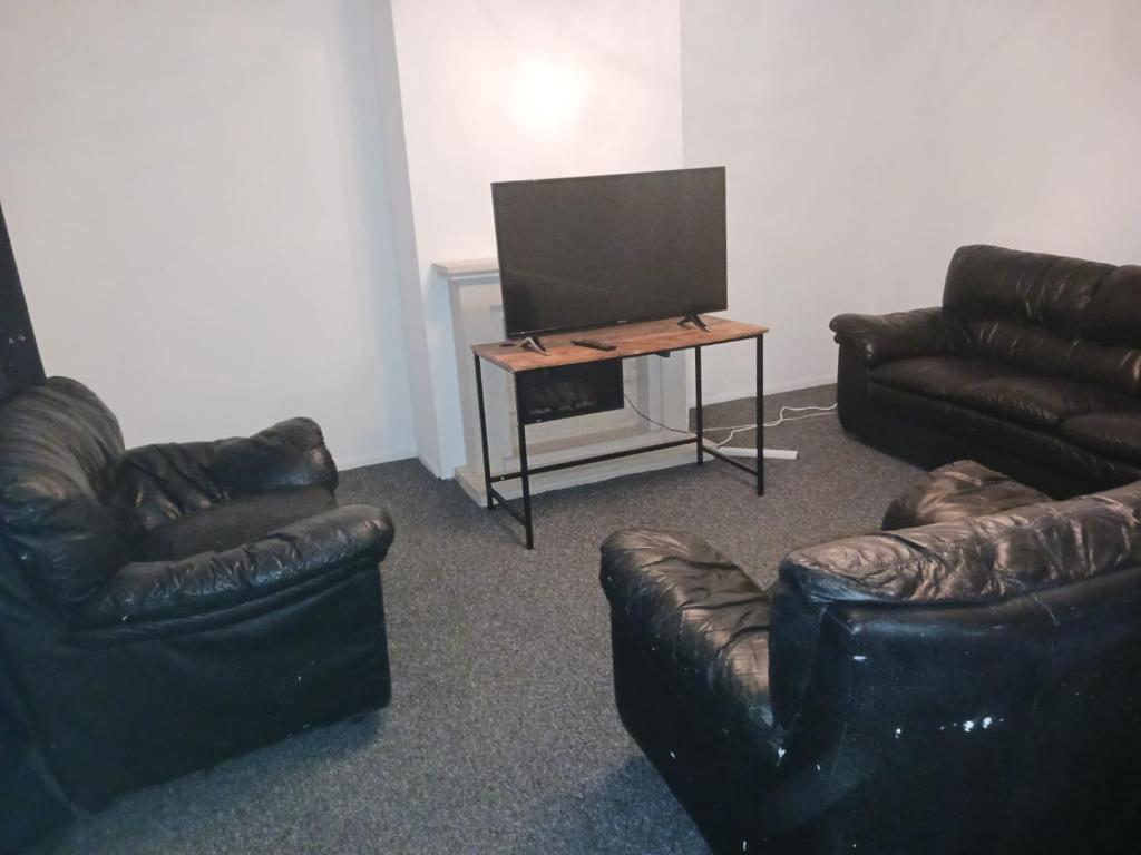 a living room with leather furniture and a flat screen tv at Iyanla HOuse in Middleton