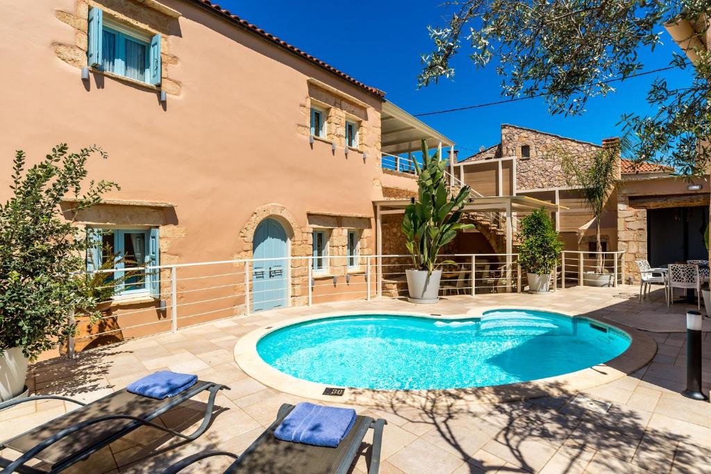 an outdoor swimming pool in front of a house at Cellar Villa in Xirosterni in Xirostérnion