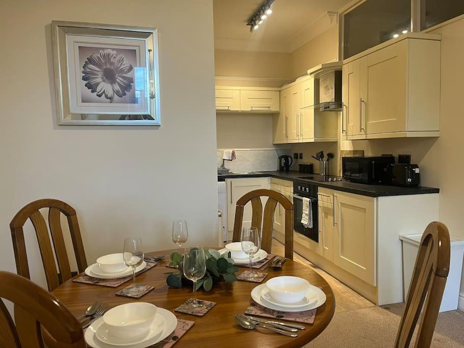 uma cozinha com uma mesa de madeira com cadeiras e uma sala de jantar em Thurnams House, Ground Floor Apt em Carlisle