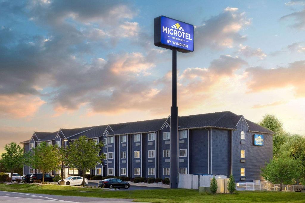a hotel with a sign in front of a building at Microtel Inn and Suites Dover in Dover