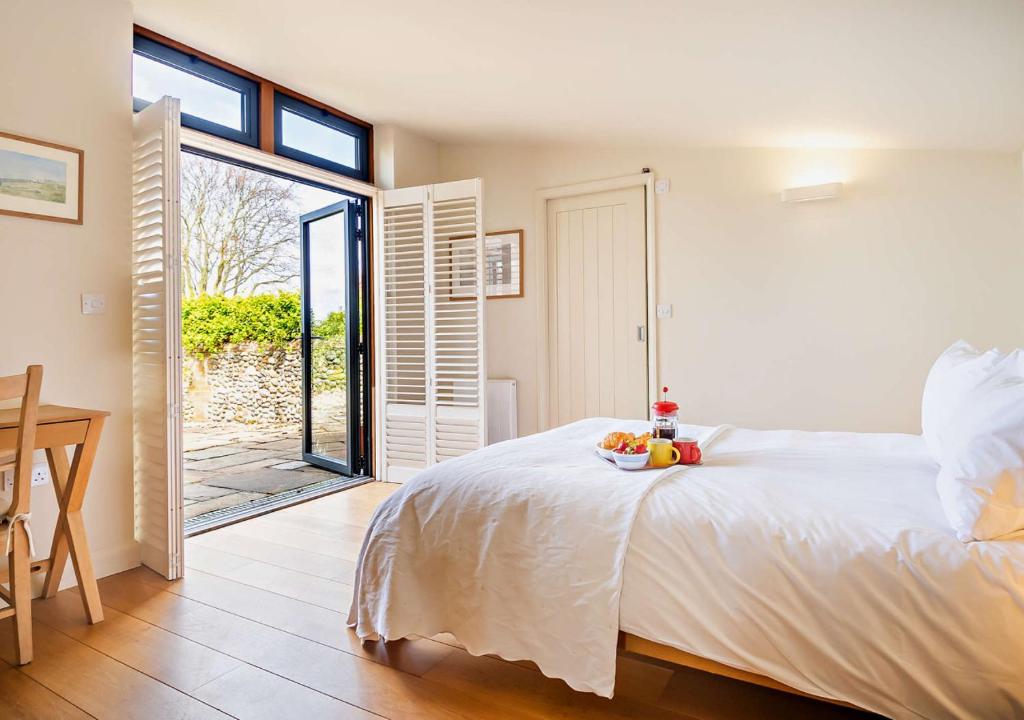 a bedroom with a bed and a sliding glass door at Farriers Cottage - Cockthorpe in Stiffkey