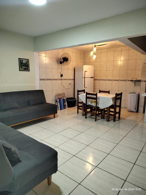 sala de estar con sofá y mesa en Aconchego famíliar, en Mongaguá