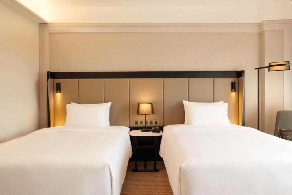 Postel nebo postele na pokoji v ubytování Hilton Kuching Hotel
