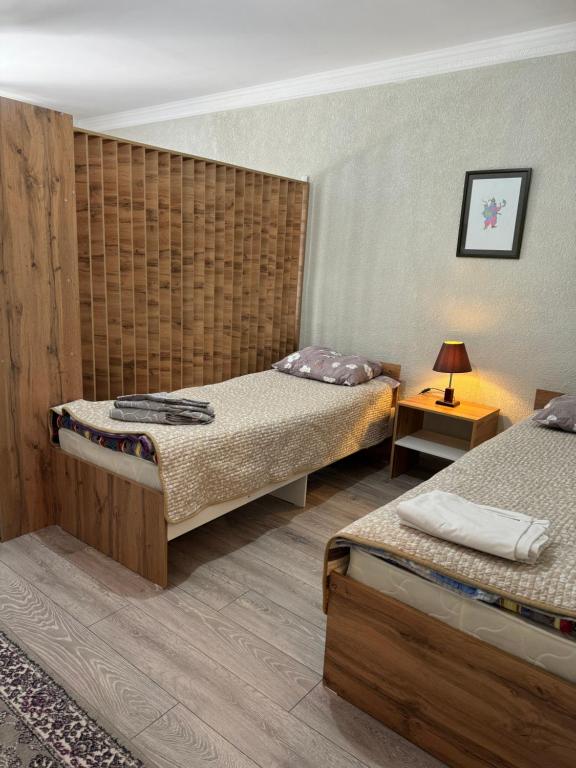 ein Schlafzimmer mit 2 Betten und einer Lampe auf einem Tisch in der Unterkunft Квартиры под соснами in Tscholponata