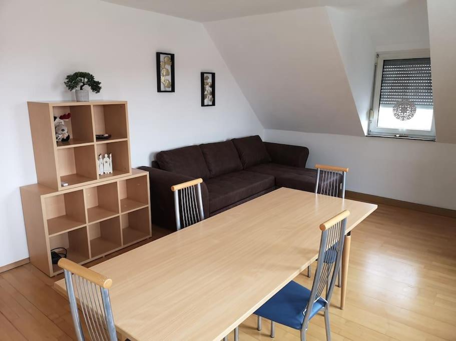 sala de estar con mesa de madera y sofá en Drei Zimmer Appartment mit Küche & Bad, en Weingarten