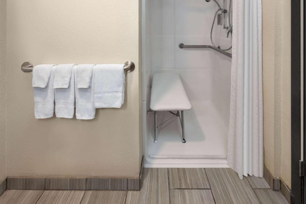 a bathroom with white towels and a shower at Super 8 by Wyndham Copley Akron in Copley