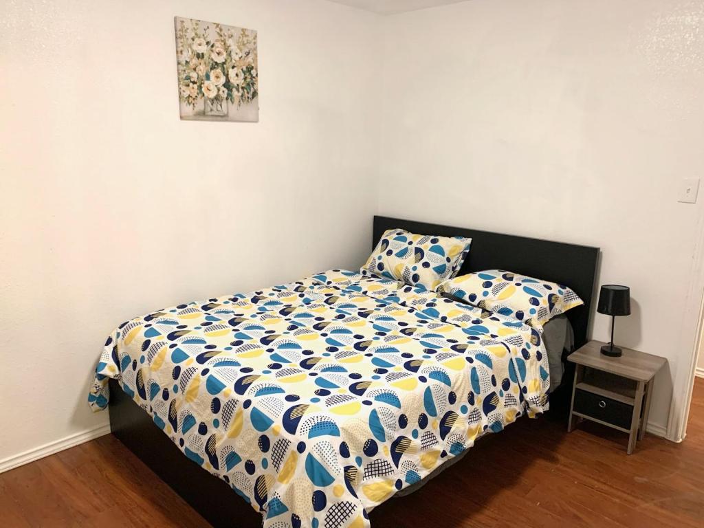 a bedroom with a bed with a yellow and blue comforter at Holiday home Dallas in Dallas