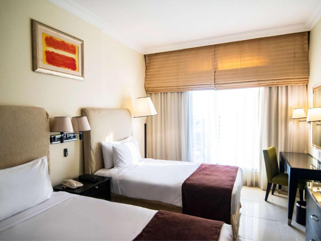 Postel nebo postele na pokoji v ubytování Mercure Dubai Barsha Heights Hotel Suites And Apartments