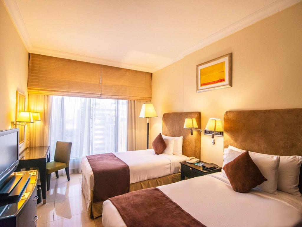 Postel nebo postele na pokoji v ubytování Mercure Dubai Barsha Heights Hotel Suites And Apartments