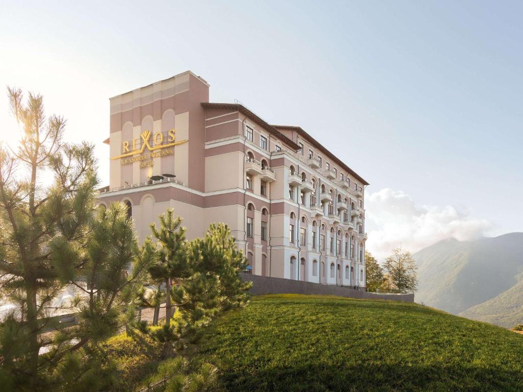 un hôtel au sommet d'une colline avec une montagne dans l'établissement Rixos Krasnaya Polyana Sochi, à Estosadok