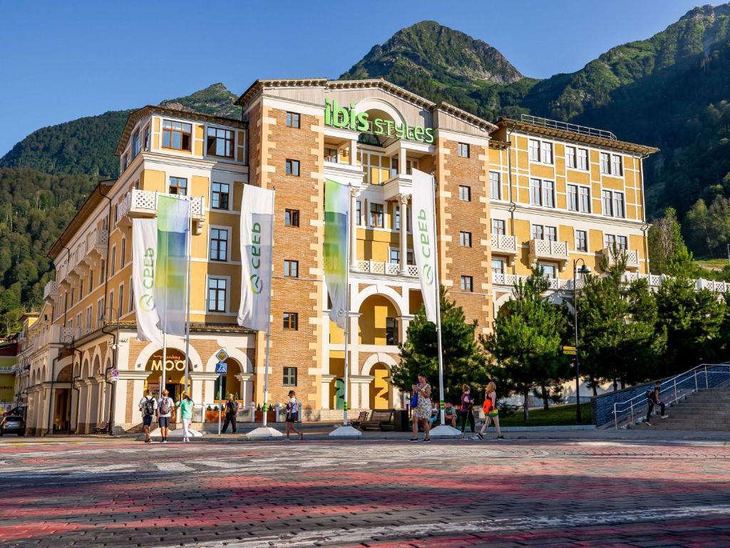 a large building with people walking in front of it at ibis Styles Krasnaya Polyana in Estosadok