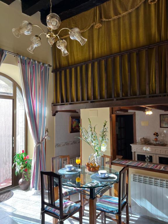 Un comedor con una mesa de cristal y sillas. en La Posada de Izan, en Gumiel de Hizán