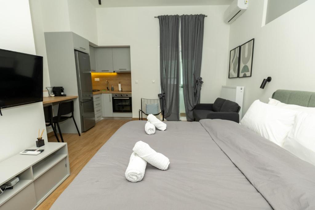 una camera da letto con un grande letto e pantofole bianche di DeKolomvou a Salonicco