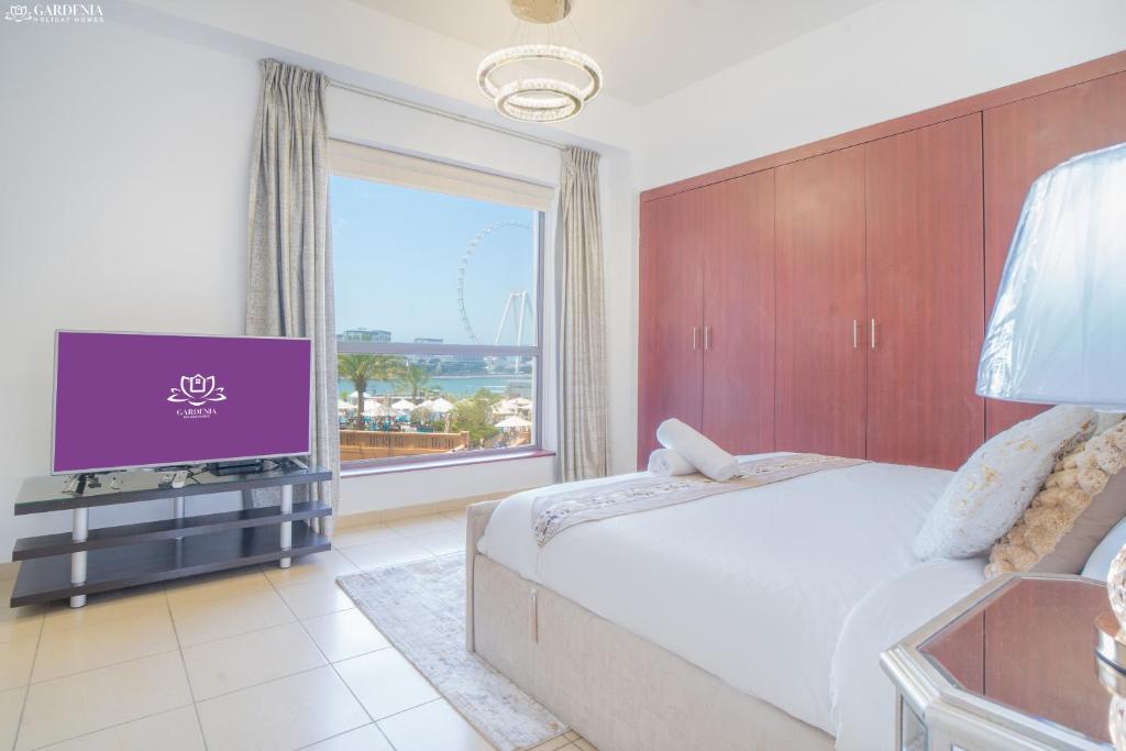 ein Schlafzimmer mit einem großen Bett und einem großen Fenster in der Unterkunft JBR The walk Rimal 6 - 3 Bedroom plus maid 2m walking to beach in Dubai