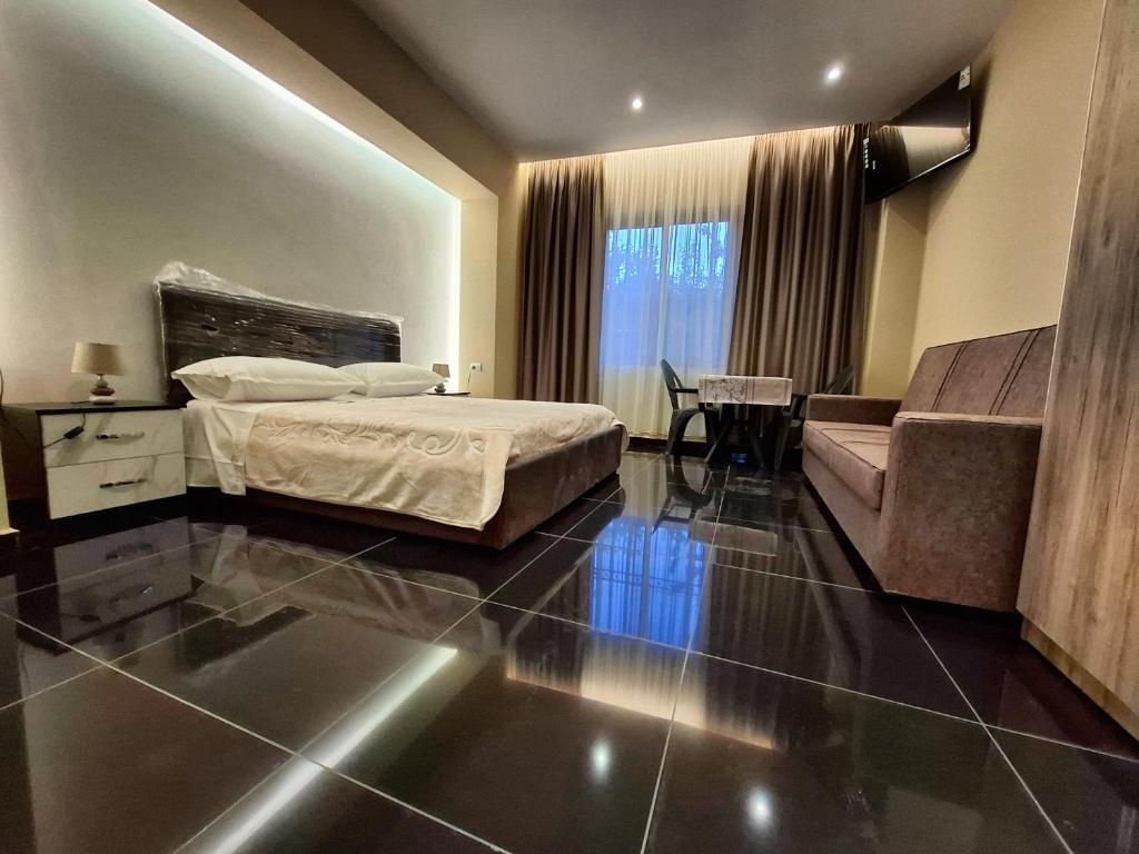 Habitación de hotel con cama y sofá en CityCenterHotel Shkoder, en Shkodër