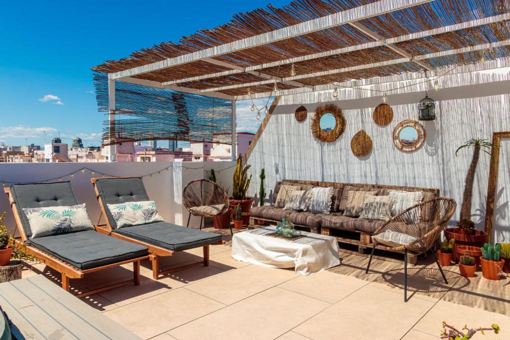 eine Terrasse mit einem Sofa und Stühlen auf dem Dach in der Unterkunft Precioso ático en Valencia. in Valencia
