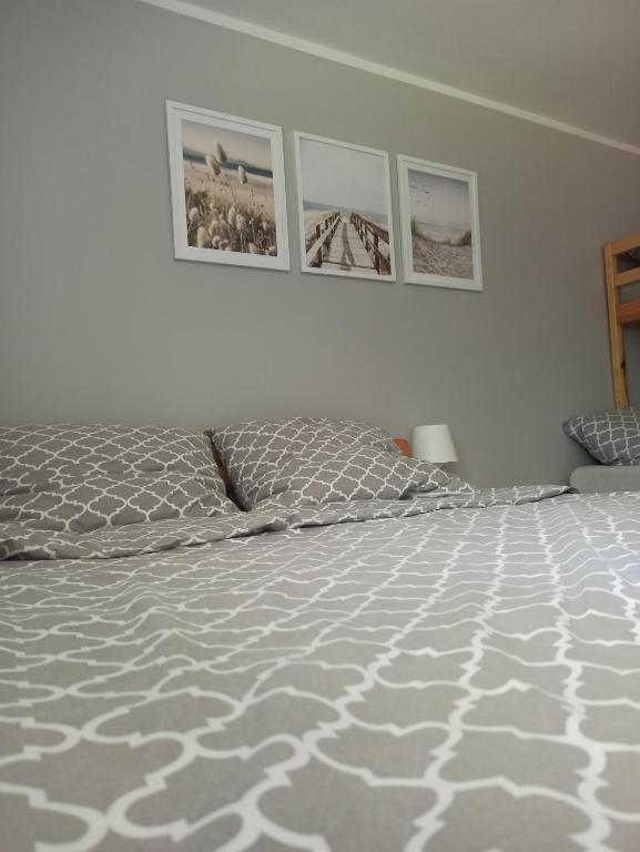 a bedroom with a bed and three pictures on the wall at Noclegi NAD NILEM in Zator