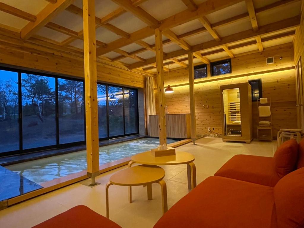 a living room with a couch and a large window at Kita Karuizawa Morino Takibi NO7 Sauna Sweet in Tsumagoi