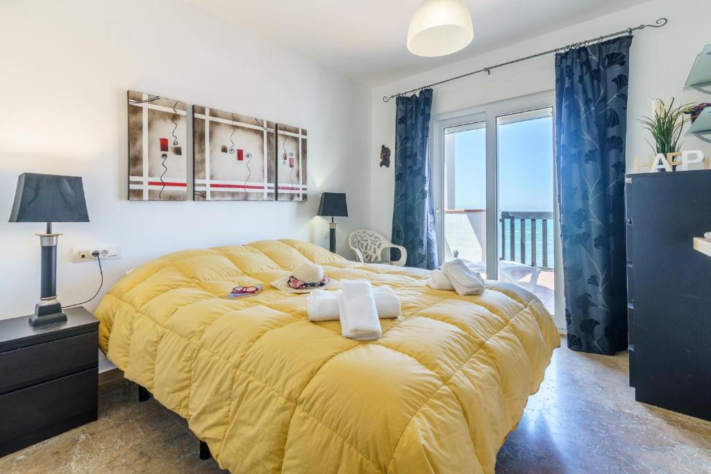 duże żółte łóżko w pokoju z oknem w obiekcie Puerta Del Mar Penthouse Beachfront - Happy Rentals w mieście Mijas Costa