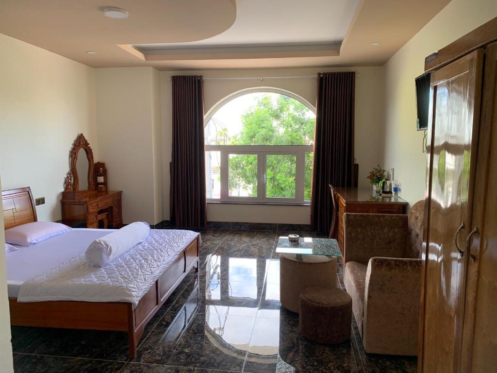 ein Schlafzimmer mit einem Bett und einem großen Fenster in der Unterkunft HOÀNG GIA BẠC LIÊU in Bạc Liêu