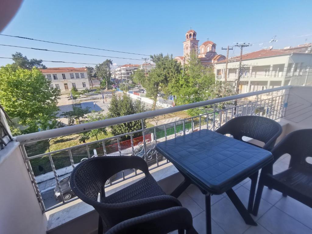 a blue table and chairs on a balcony with a view at INFINITY Center Apartment in Nea Kallikrateia