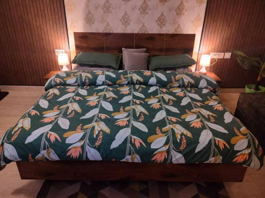 um quarto com uma cama com um edredão colorido em Blue Heart Home~1BHK Luxury & Cosy Flat in Tapovan em Rishikesh