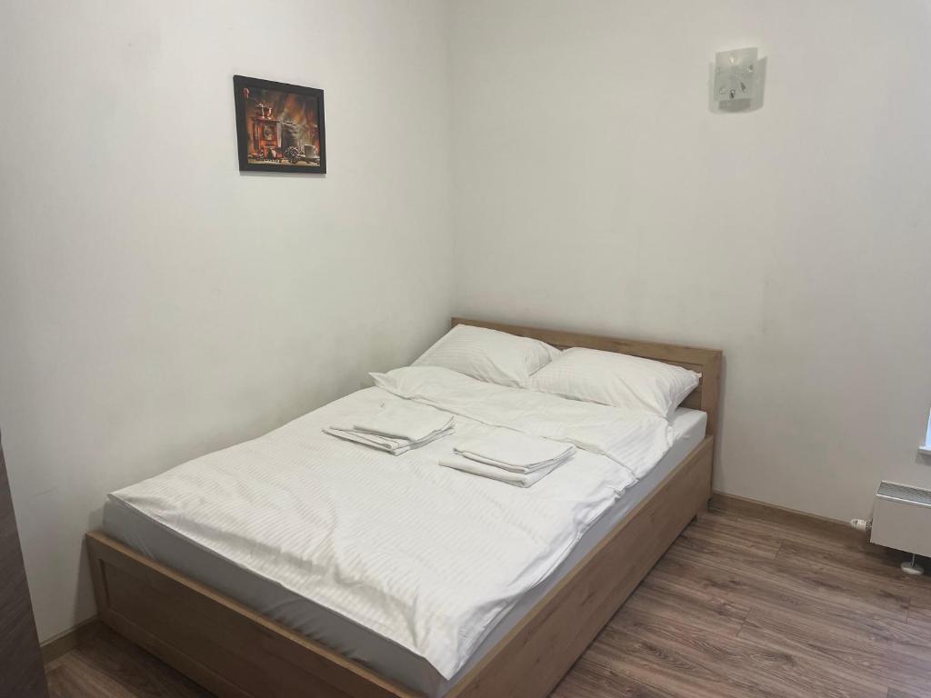 ein Bett mit weißer Bettwäsche und weißen Kissen in der Unterkunft Apartamenty 3 Kraków Podgórze in Krakau