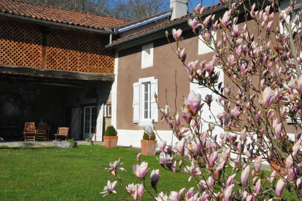 Le CAP DE CLOS في Cier-de-Rivière: شجرة بالورود الزهري أمام المنزل