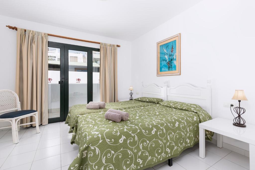 1 dormitorio con 1 cama con 2 almohadas en Apartamentos Erika - Adults Only, en Corralejo