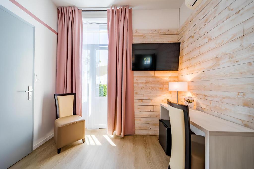 TV a/nebo společenská místnost v ubytování Hôtel Le Rabelais