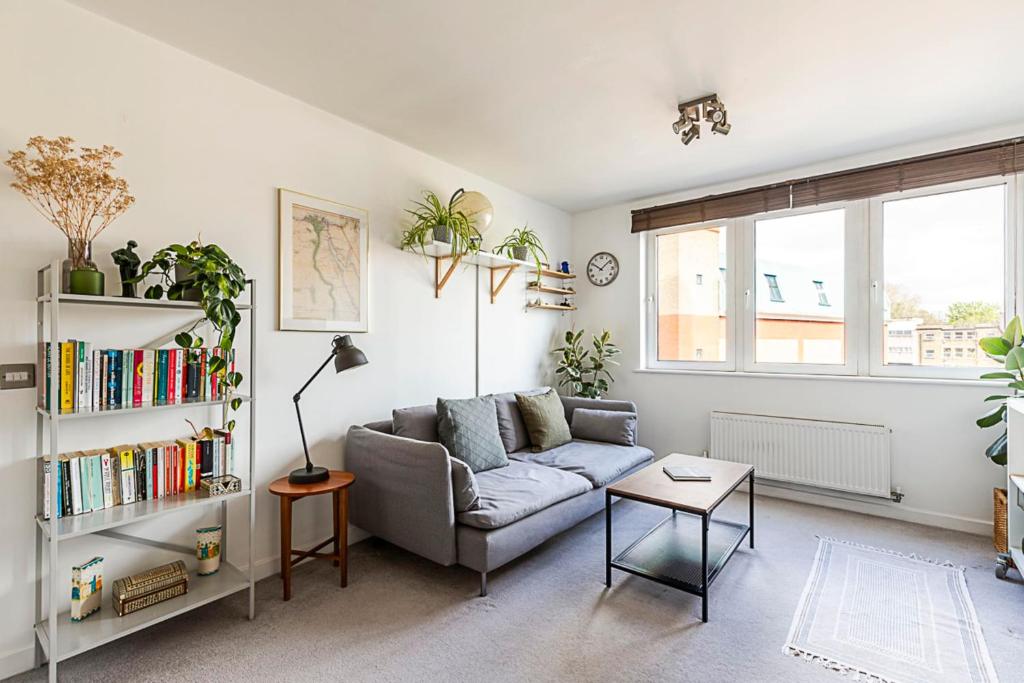 ein Wohnzimmer mit Sofa und Bücherregal in der Unterkunft Urban and Stylish Apartment in London