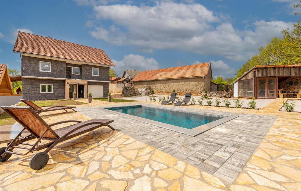 Lovely Home In Gracac With Outdoor Swimming Pool في Gračac: حديقه خلفيه بها مسبح ومنزل
