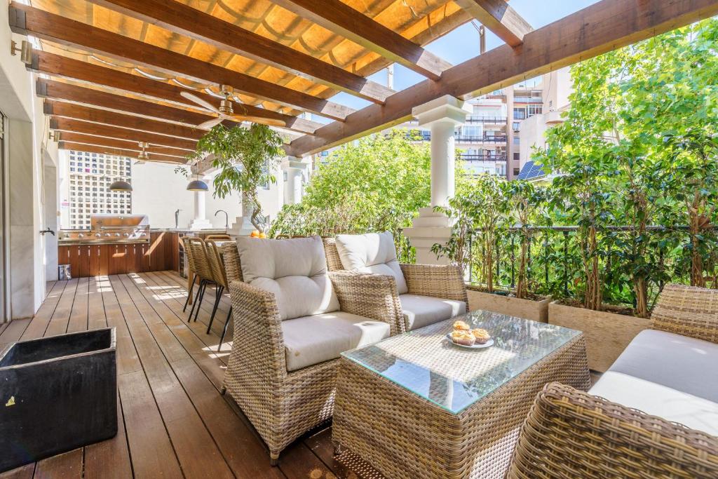 um pátio exterior com mobiliário de vime e uma pérgola em Duplex Marbella Concordia Close To Beach em Marbella