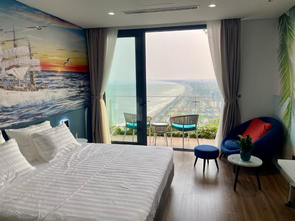 a bedroom with a large bed and a large window at Flamingo Hải Tiến in Thanh Hóa