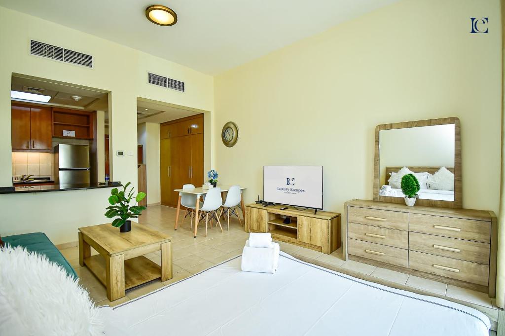 a living room with a large mirror and a kitchen at Luxury Escapes - Tranquil Retreat - Studio Apts near Metro and Mall - Discovery Gardens - SHAR & MCL in Dubai