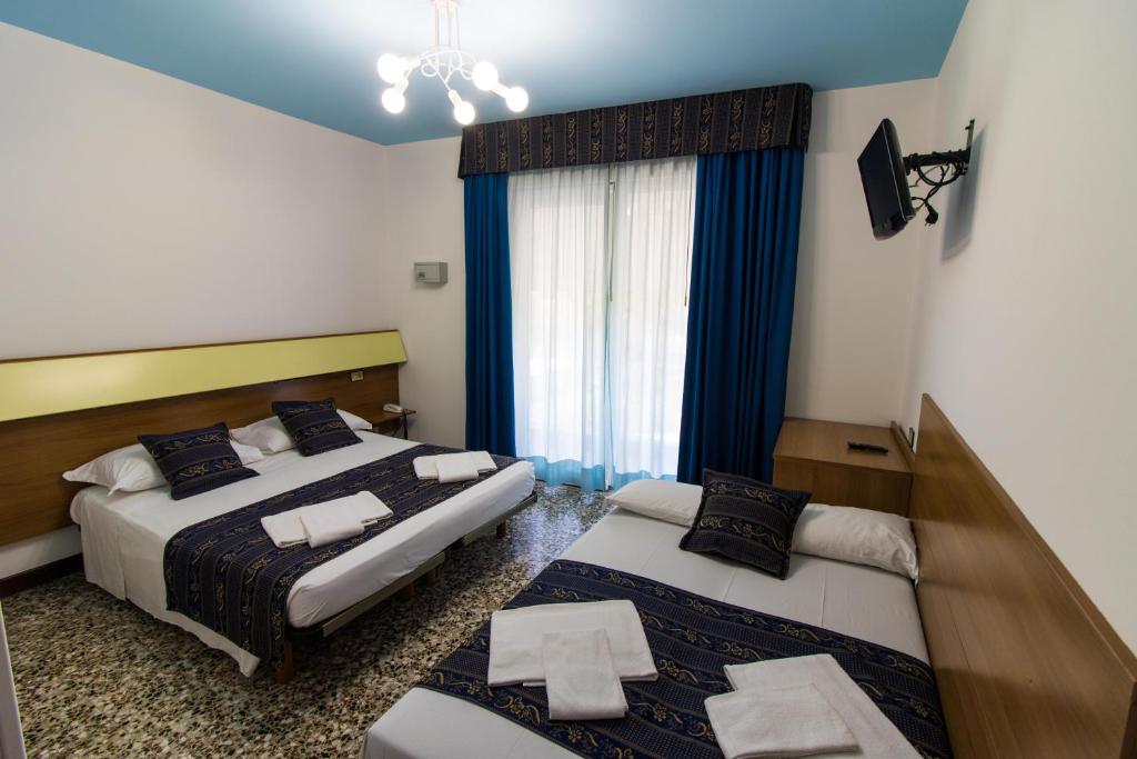 a hotel room with two beds and a window at BlueColors Hotel ex Hotel Lucy in Campalto