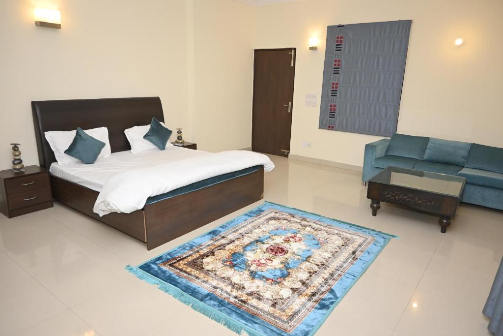 新德里的住宿－ownstay chhatarpur，一间卧室配有一张床和一张蓝色的沙发