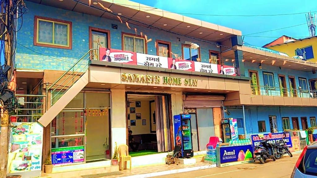 un edificio azul con un cartel para una tienda en Samarth home`stay, en Pachmarhī
